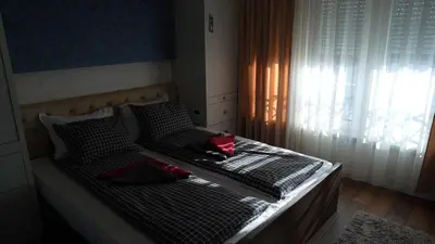 a bed with two pillows on it with a window at Bella studios in Kruševac