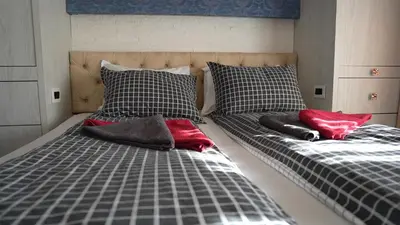 two beds with red pillows on them in a bedroom at Bella studios in Kruševac