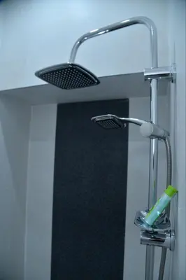 a bathroom with a shower with a toothbrush under a sink at Bella studios in Kruševac