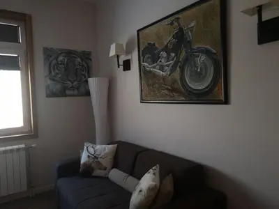 a living room with a couch and a motorcycle on the wall at Lonka apartman Kopaonik in Kopaonik