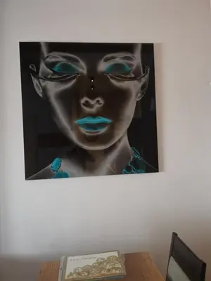 a painting of a woman with blue lips on a wall at Lonka apartman Kopaonik in Kopaonik