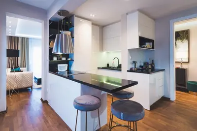 a kitchen with a counter and stools in a room at Majestic Apartment in Jagodina