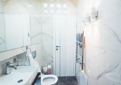 a white bathroom with a sink and a toilet at Majestic Apartment in Jagodina