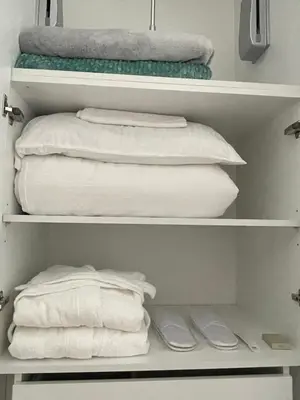 a closet with white towels and a pile of towels at Majestic Apartment in Jagodina