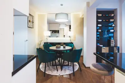 a dining room with a table and green chairs at Majestic Apartment in Jagodina