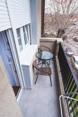 a small balcony with a table and two chairs at Majestic Apartment in Jagodina