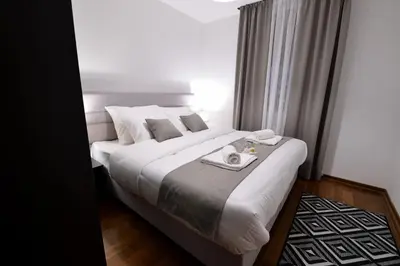 a bedroom with a large bed with a towel on it at Apartman DiamondLux Vrnjacka Banja in Vrnjačka Banja