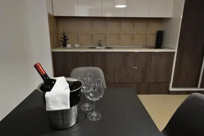 a table with wine bottles and wine glasses on it at Apartman DiamondLux Vrnjacka Banja in Vrnjačka Banja