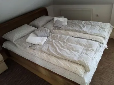 an unmade bed with towels and pillows on it at Apartman Gordana in Vrnjačka Banja