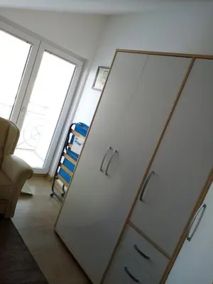 a mirror in the corner of a room with a chair at Apartman Gordana in Vrnjačka Banja