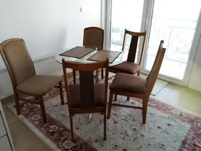 a dining room table with four chairs and a window at Apartman Gordana in Vrnjačka Banja