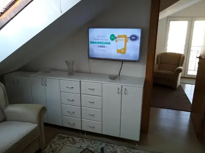 a living room with a tv and a staircase at Apartman Gordana in Vrnjačka Banja