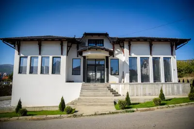 a white house with a flag in front of it at Prenociste ADRIA in Vranje