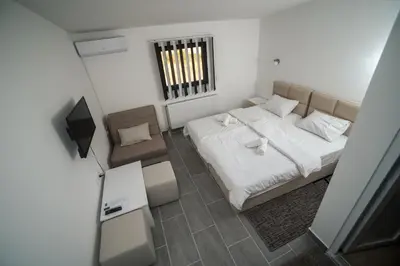 a small bedroom with a bed and a chair at Prenociste ADRIA in Vranje