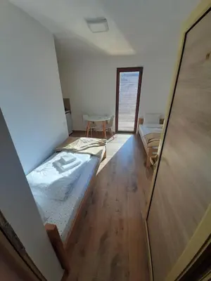 a room with two beds and a table at Studio Gmitrovic in Rtanj