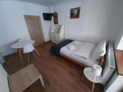 a small bedroom with a bed and a table at Studio Gmitrovic in Rtanj