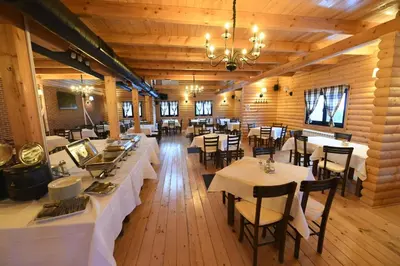 a dining room with tables and chairs in a building at The Nest Apartman, Župa Wellness & Spa Kopaonik in Kopaonik