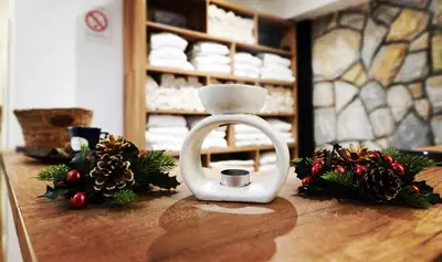 a white candle holder on a table with christmas decorations at The Nest Apartman, Župa Wellness & Spa Kopaonik in Kopaonik