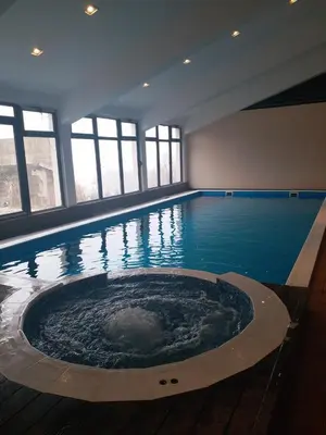 a large swimming pool with a large tub in a building at The Nest Apartman, Župa Wellness & Spa Kopaonik in Kopaonik