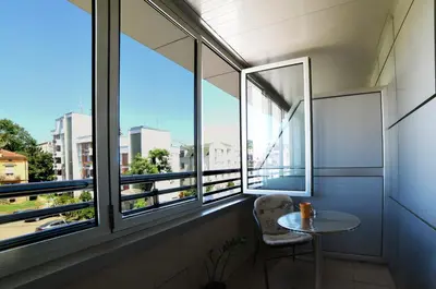 a small table in a room with windows at Dental apartman in Vrnjačka Banja