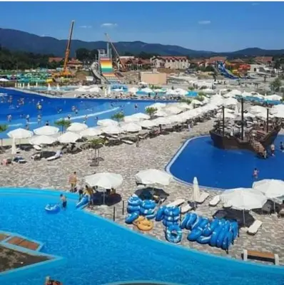 a pool with blue chairs and umbrellas at a water park at NOVAK apartman in Vrnjačka Banja