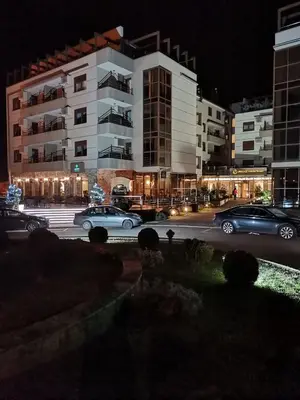 a parking lot with cars parked in front of a building at NOVAK apartman in Vrnjačka Banja
