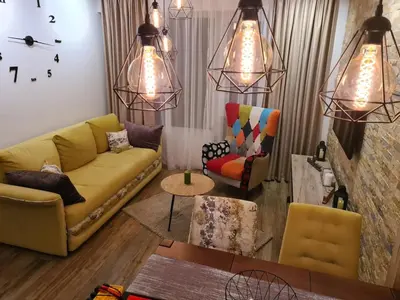 a living room with a yellow couch and two chairs at Hedonic in Kopaonik