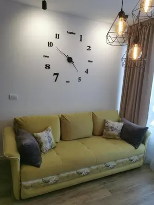a large clock on a wall above a couch at Hedonic in Kopaonik