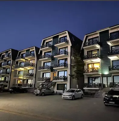 two cars parked in a parking lot in front of a building at Hedonic in Kopaonik