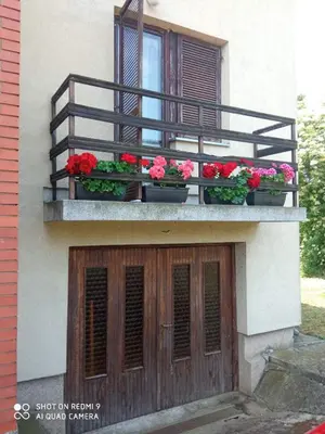 a building with flower boxes on a balcony at Vila Milica in Kraljevo