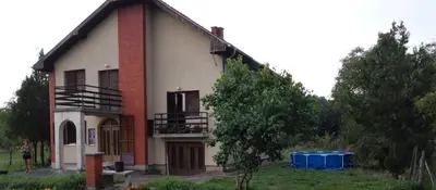 a house with a blue trash can in front of it at Vila Milica in Kraljevo