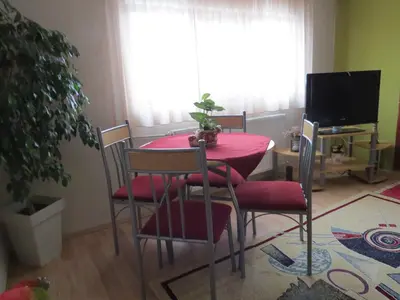a dining room with a red table and chairs at Apartman Bilja in Vrnjačka Banja
