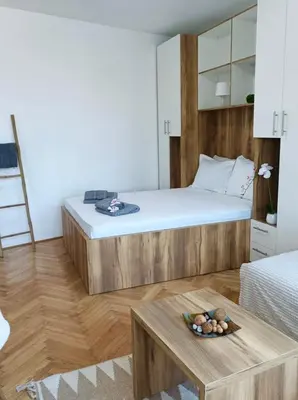 a bedroom with a large bed and a table at Apartman Rajska Banja in Vrnjačka Banja