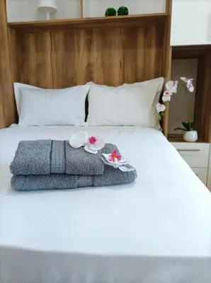 a bed with two towels and flowers on it at Apartman Rajska Banja in Vrnjačka Banja