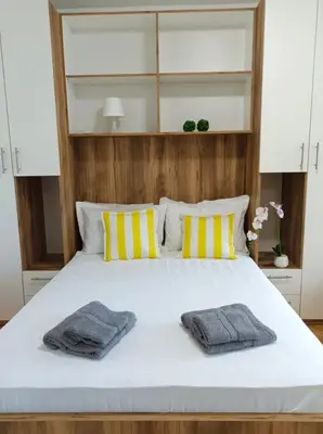 a bedroom with a white bed with two towels on it at Apartman Rajska Banja in Vrnjačka Banja