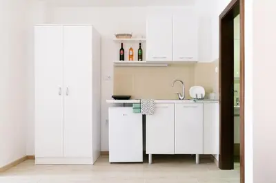 a kitchen with white cabinets and a sink at Apartmani Veselinović in Vrnjačka Banja