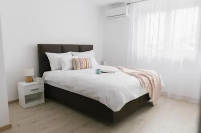 a bedroom with a large bed and a window at Apartmani Veselinović in Vrnjačka Banja