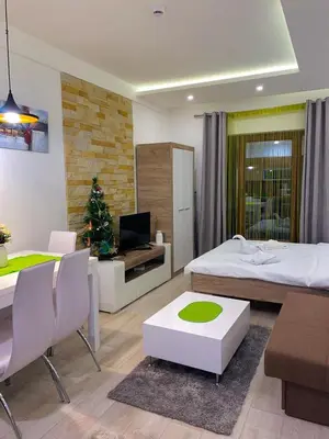 a bedroom with a bed and a dining room with a christmas tree at MILMARI APARTMAN P03 in Kopaonik