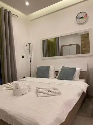 a bedroom with a large white bed with towels on it at MILMARI APARTMAN P03 in Kopaonik