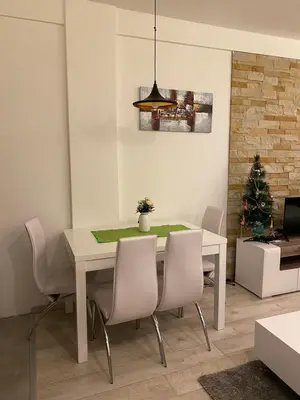 a dining room with a table and chairs and a christmas tree at MILMARI APARTMAN P03 in Kopaonik