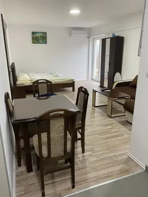 a dining room and living room with a table and chairs at Studio Milica in Soko Banja