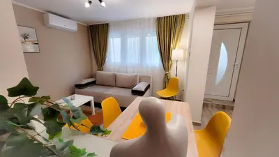 a living room with a table and yellow chairs at Vila Nikola in Soko Banja