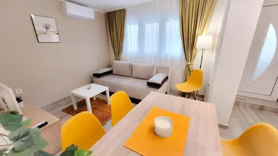 a living room with a table and yellow chairs at Vila Nikola in Soko Banja