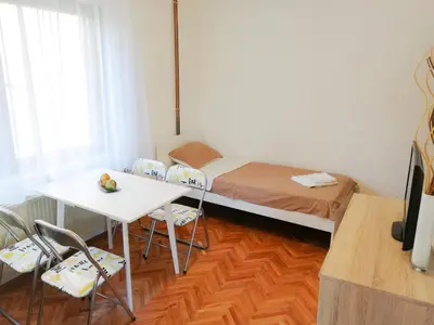 a small room with a bed and a table and chairs at Vila Nikola in Soko Banja