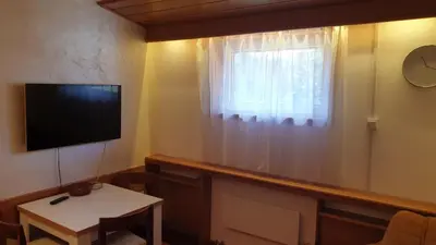 a living room with a tv and a window at Apartman 602 in Kopaonik