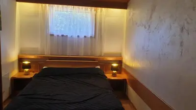 a bedroom with a bed and a window with lights at Apartman 602 in Kopaonik