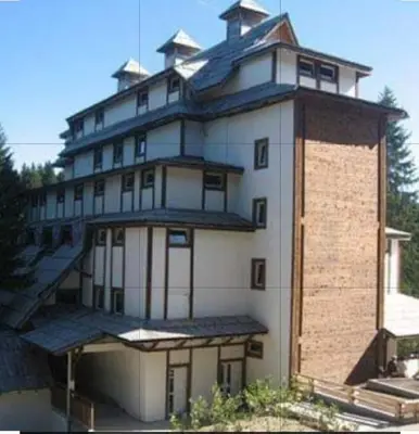 a large white building with a tower on top at Apartman 602 in Kopaonik