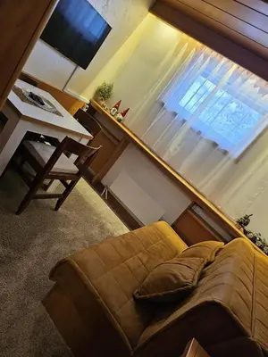 a living room with a couch in front of a window at Apartman 602 in Kopaonik