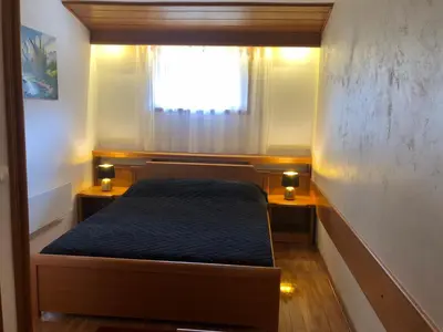 a small bed in a small room with a window at Apartman 602 in Kopaonik
