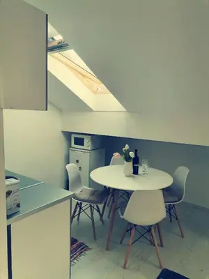 a white table and chairs in a room with a kitchen at Apartman ST.Nedeljkovic Sokobanja in Soko Banja